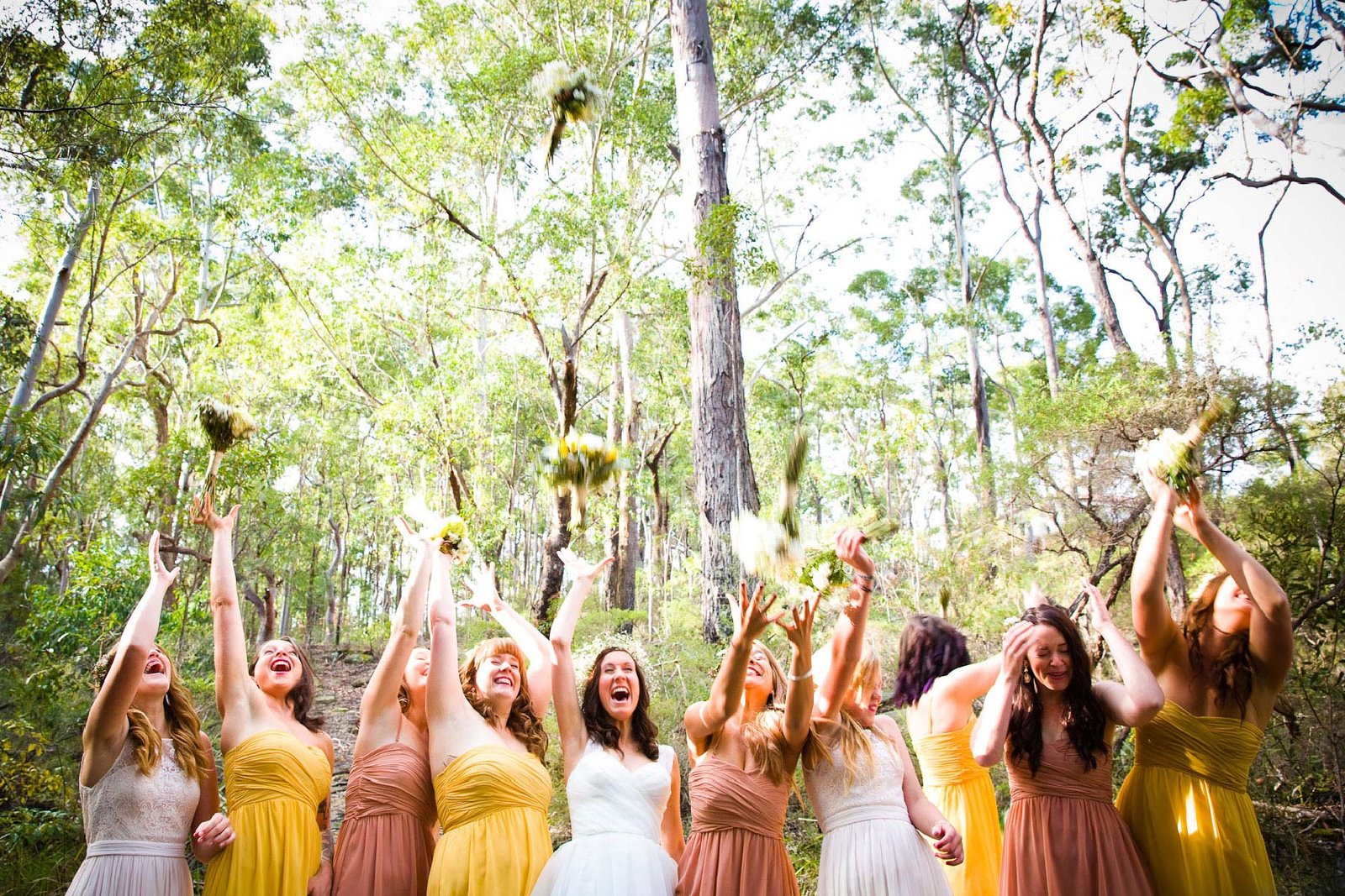 bridesmaids throwing flowers candid wedding photography