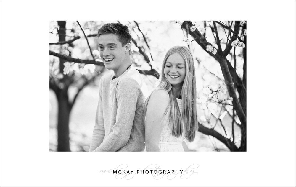 black white photo siblings laughing