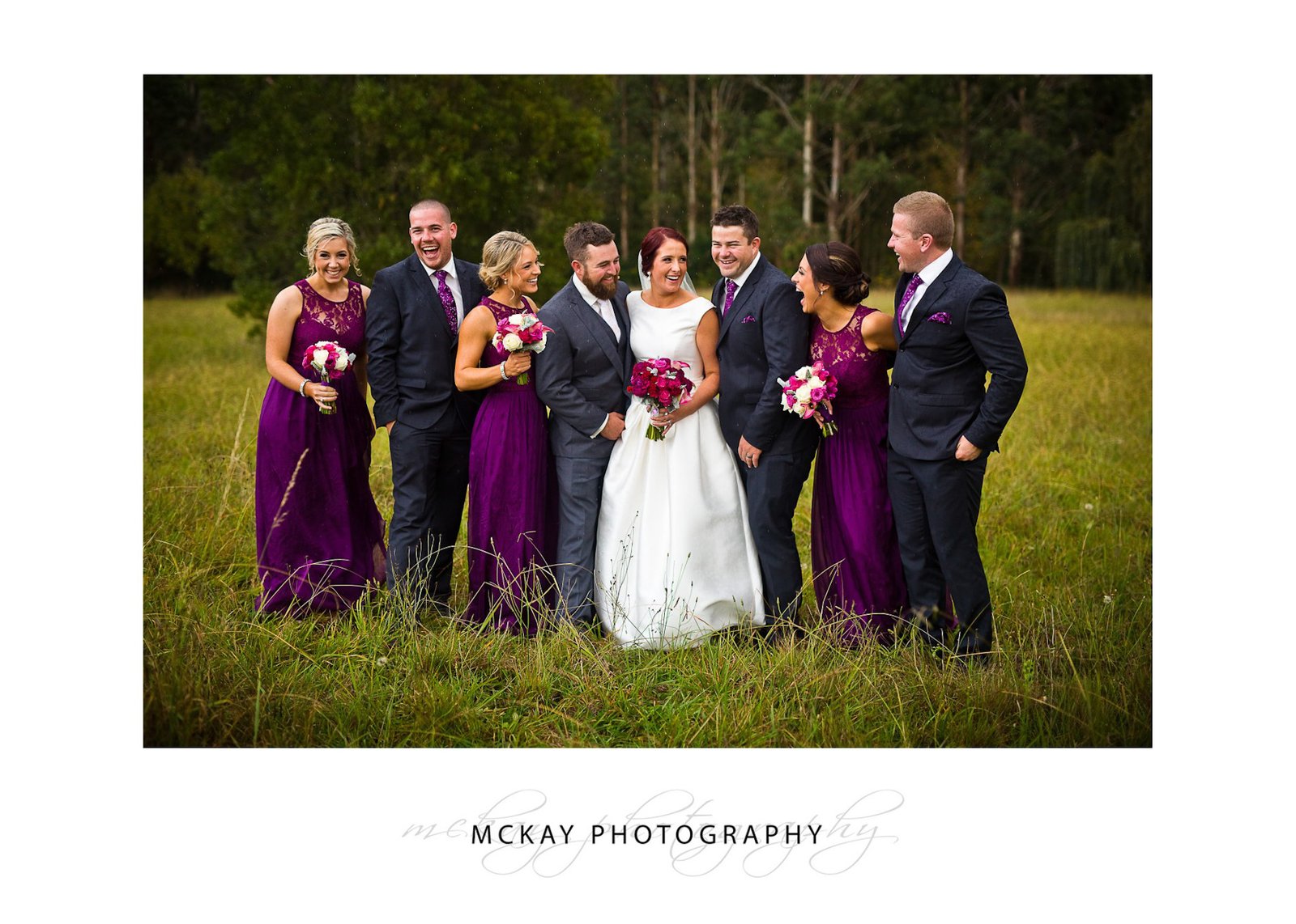 Bridal party in rain laughing Bowral grass field