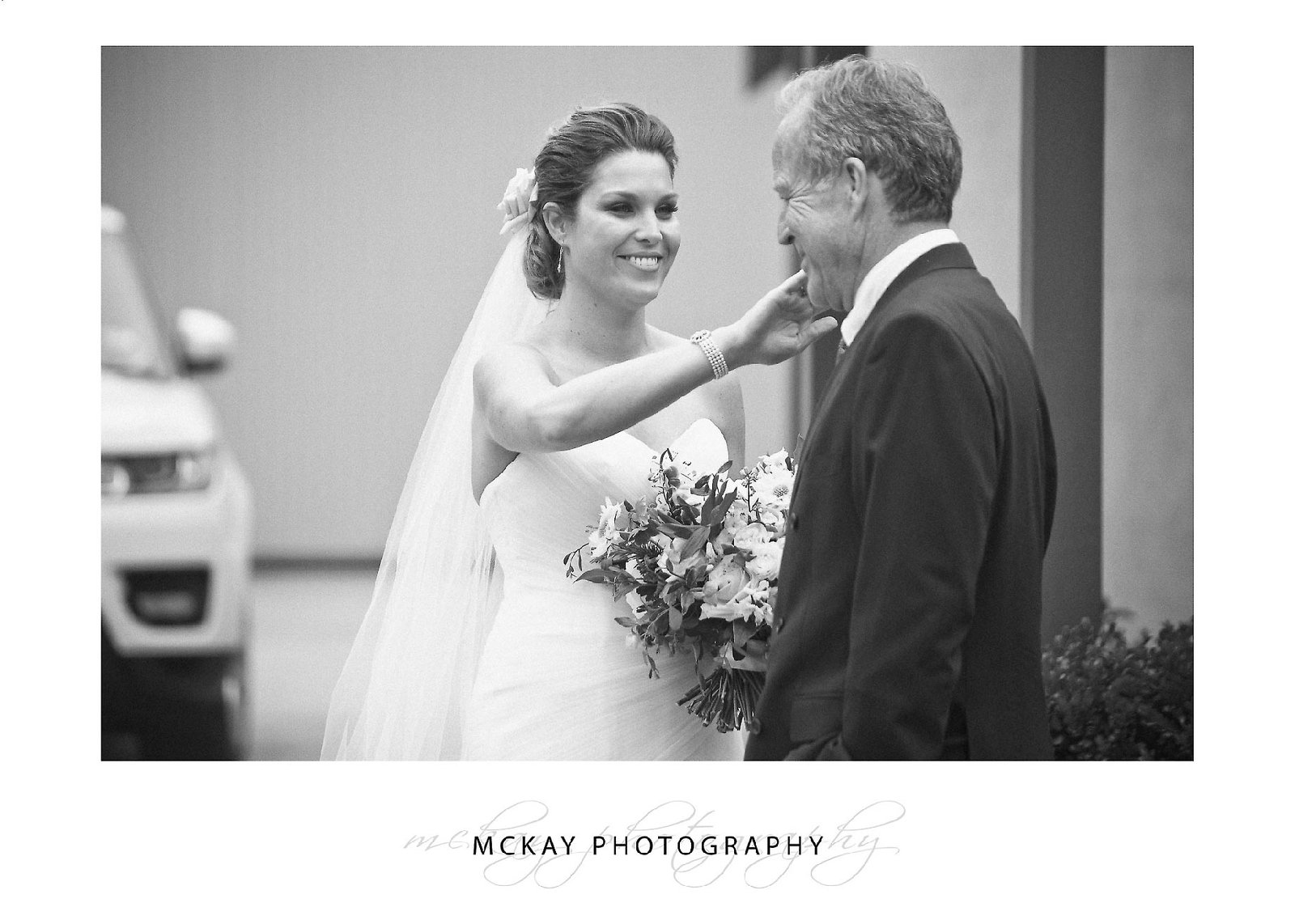 Bride wiping tear from Fathers eye before ceremony