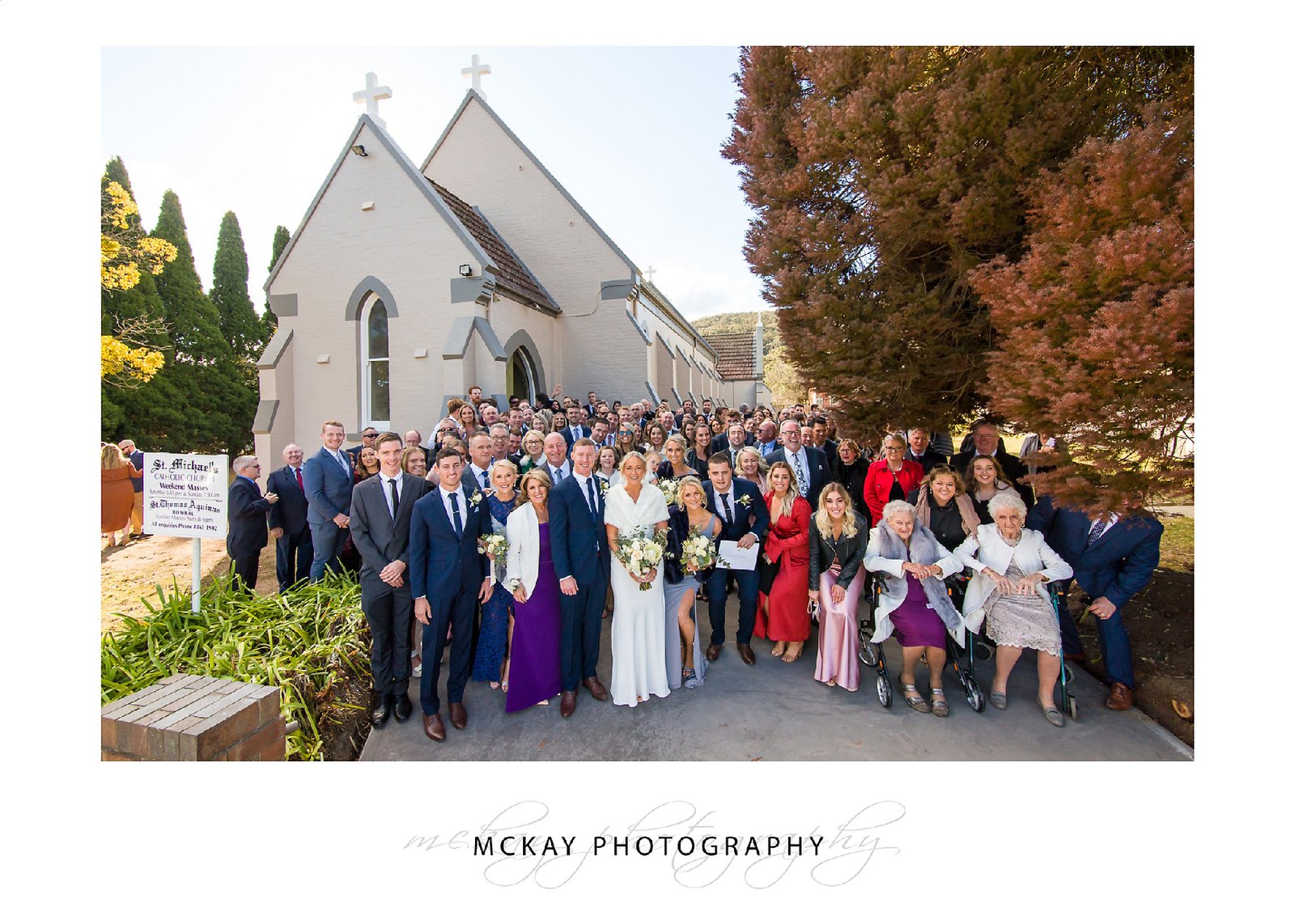 Group wedding photo outside St Michael's Church in Mittagong
